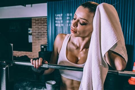 Premium Photo Fit Blonde Woman Resting After Training Lifting A Bar Weights In Gym