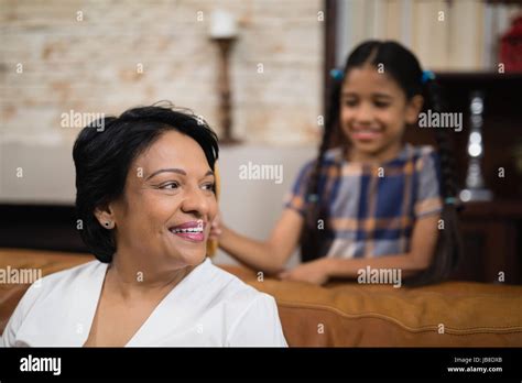 Smiling Mature Woman Sitting On Sofa At Home Stock Photo Alamy