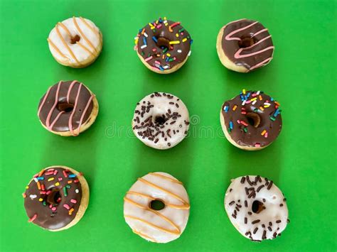 Nine Round Mini Decorated Donuts Arranged On Green Background Stock