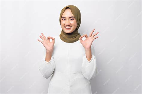 아름 다운 미소 친절 한 젊은 아라비아 아시아 이슬람 여자 Hijab 흰색 배경에 고립 된 확인 괜찮 기호를 입고 입고 사람들이