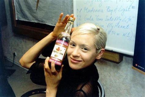 a woman holding up a bottle of wine in front of a whiteboard with ...