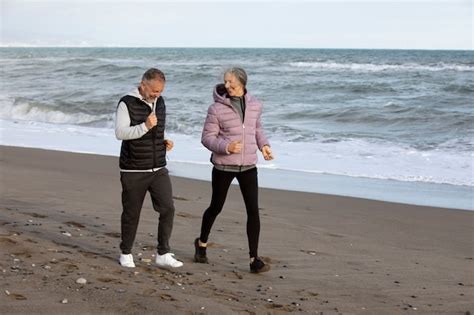 Personas Mayores De Tiro Completo Corriendo En La Playa Foto Gratis