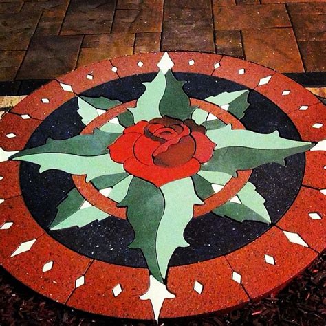 A Red Rose Painted On The Ground In Front Of A Brick Walkway With White