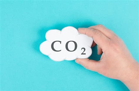 A mão segura a nuvem a palavra CO 2 reduz a emissão de dióxido de