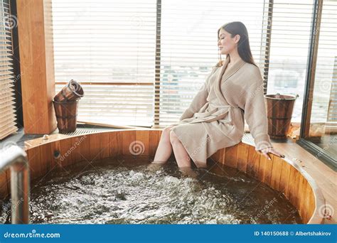 Brunette Woman Relaxing In Jacuzzi In Spa Center With Panoramic Windows