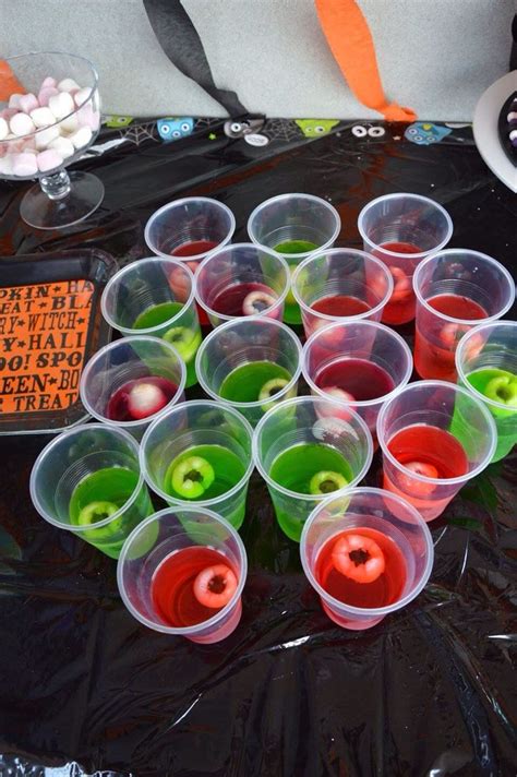 Plastic Cups Filled With Different Colored Liquid On Top Of A Black