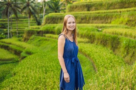 Mujer joven en la plantación de campo de arroz en cascada verde en la