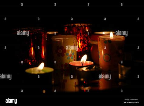 Lit Candles With Flames Flickering In The Darkness At Nighttime Stock