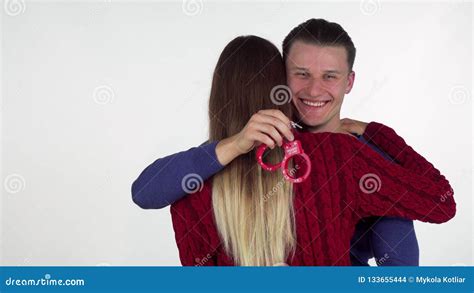 Handsome Man Hugging His Girlfriend Holding Sex Toy Handcuffs Behind