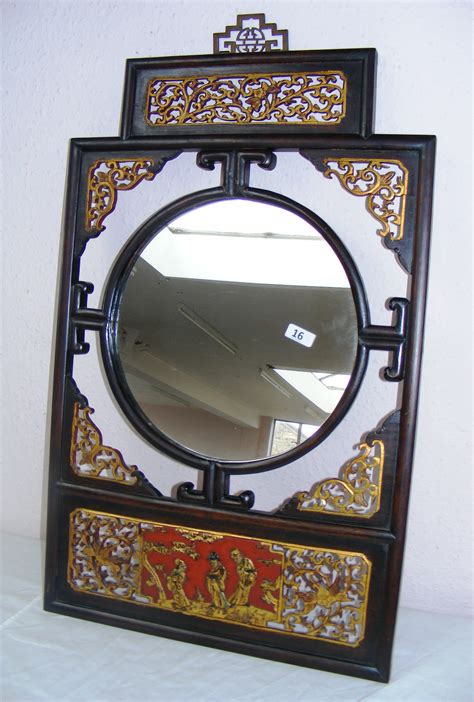 An early 20th century Japanese style mirror with figural carvings and