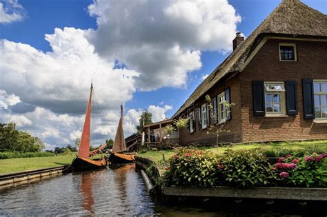 Traditional Dutch Brick Houses With Lush Green Lawns On A Water Canal