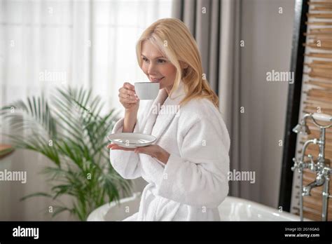 Good Looking Blonde Woman Having Tea And Looking Balanced Stock Photo Alamy