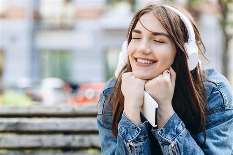 Mulher Jovem E Sorridente Ouvindo Música Com Fones De Ouvido Garota