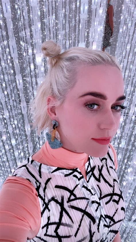 A Woman With Blonde Hair And Blue Eyes Posing For A Photo In Front Of Silver Sequins