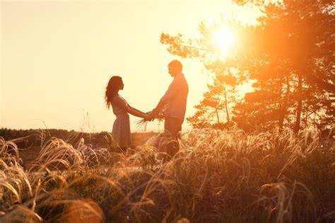 Joven Pareja Cogidos De La Mano En La Naturaleza Del Amanecer Foto