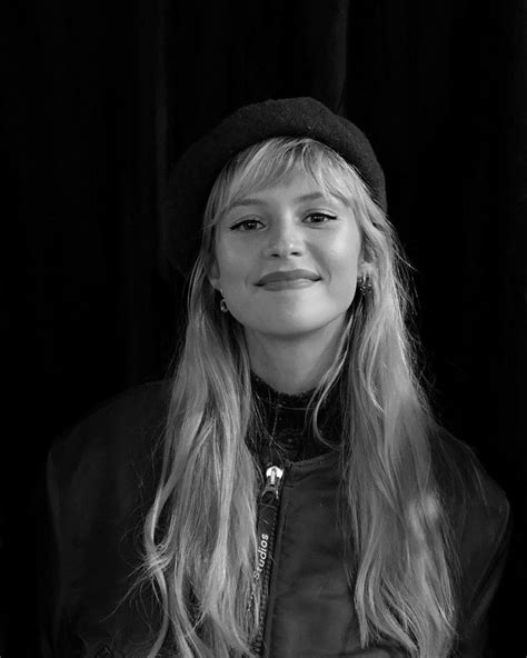 A Black And White Photo Of A Woman With Long Blonde Hair Wearing A Hat