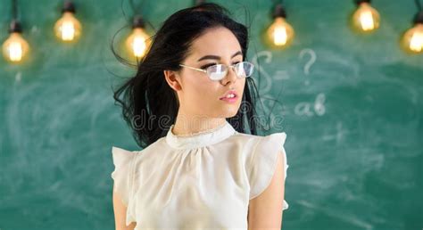 Woman With Long Hair In White Blouse Stands In Classroom Teacher With