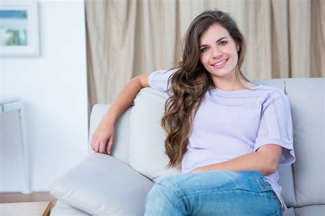 Premium Photo Happy Brunette On Couch Smiling At Camera