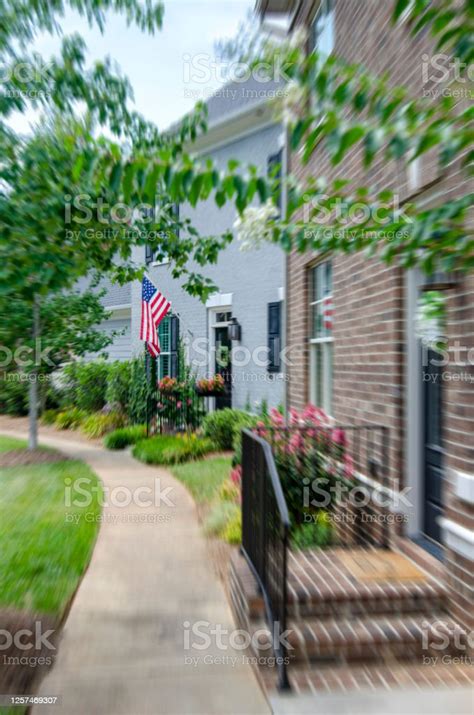 Front Porch Of A House With An American Flag Featuring Small Town