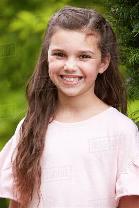 Portrait Of Smiling Young Girl Standing Outdoors In Garden Stock