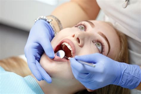 Dentista Feminina Verificando Os Dentes Do Paciente Foto Premium