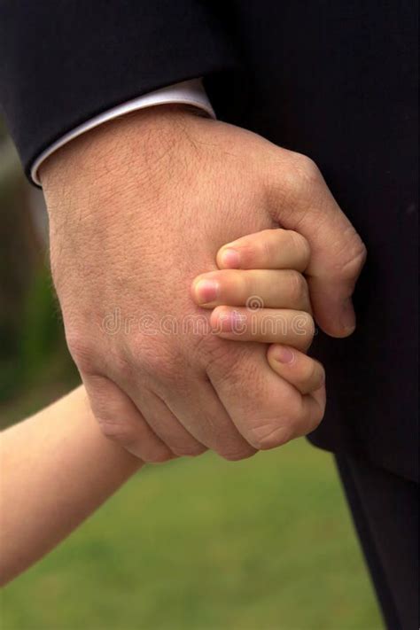 Father And Son Holding Hands A Son Tightly Holds His Father S Hand