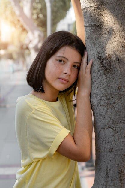 Una Chica Joven Y Bonita Se Inclin Contra Un Rbol Foto Premium