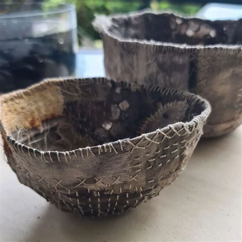 Two Bowls Sitting On Top Of A Table Next To Each Other With Holes In Them