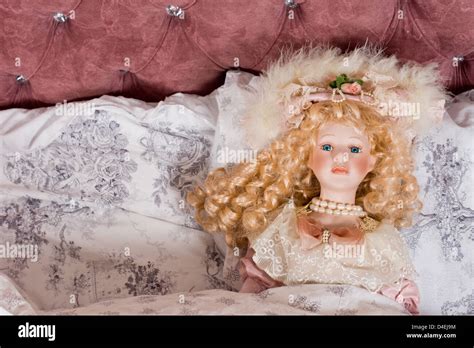 Face Of A Beautiful Vintage Doll With Her Long Blonde Hair In Ringlets And Wearing Pearls And A