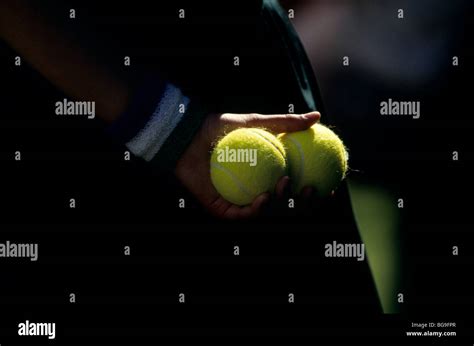 Close up of a ball girl holding tennis balls behind his back Stock Photo - Alamy