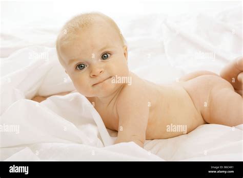 A Nude Six Month Old Baby Lying On Her Front On White Fabric Stock Photo Alamy
