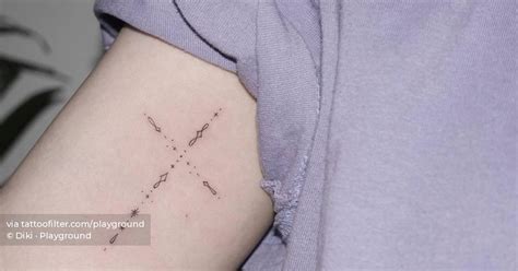 Symbol chain cross tattoo on the inner arm.