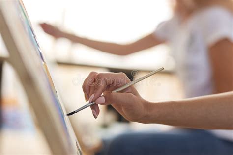 Girls Hand Holds A Paint Brush Process Of Painting Picture At The