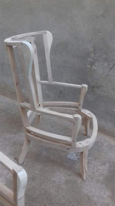 A Wooden Rocking Chair Sitting Next To A Concrete Wall And Cement Floor