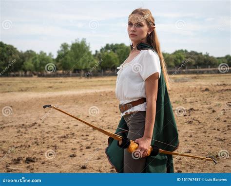La Fille Blonde Avec Des Oreilles D Elfe Pose Dans Le Domaine Avec Un Arc Et Un Cap Vert Image