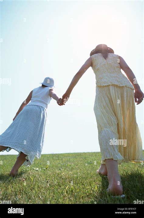 Women Walking Hand In Hand Stock Photo Alamy