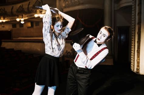 Free Photo | Female mime artist hitting male mime artist with script