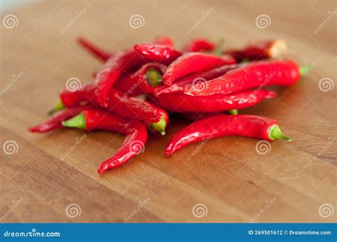 Red Hot Chili Peppers Indoors On A Wooden Cutting Board Stock Photo