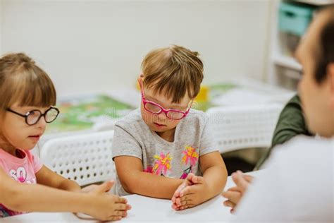 Ni Os Con S Ndrome De Down Estudiando En La Habitaci N Con Escritorios