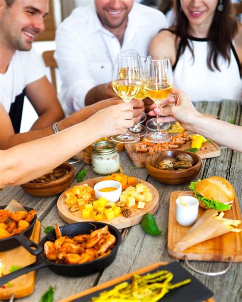 Manos Con El Vino Rojo Que Tuesta Sobre La Tabla Servida Con La Comida