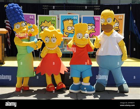 Characters Dressed As The Simpsons From Left Marge Holding Maggie Lisa Bart And Homer Pose