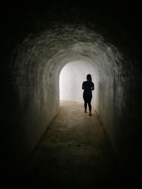 Premium Photo Rear View Of Silhouette Man Walking In Tunnel