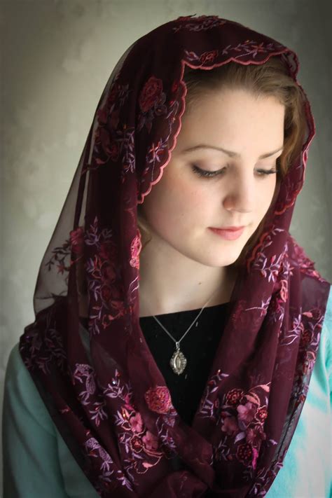 A Woman Wearing A Purple Scarf With Flowers On It And A Necklace In Her