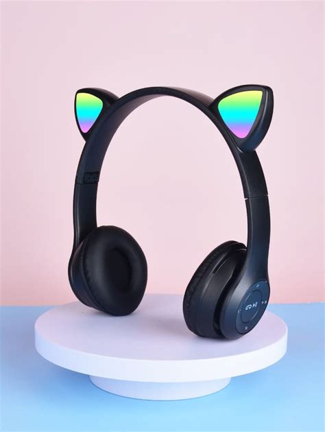 A Pair Of Black Headphones With Cat Ears On Top Of A White Stand In