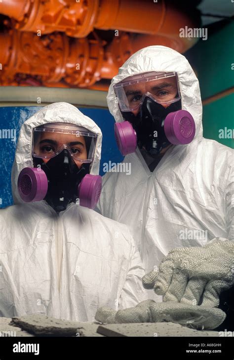 Asbestos Removal Worker With Protective Suit And Mask At Industrial