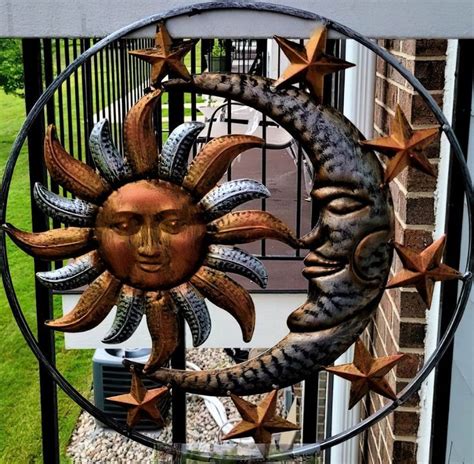 A Metal Sun And Moon Decoration In Front Of A House