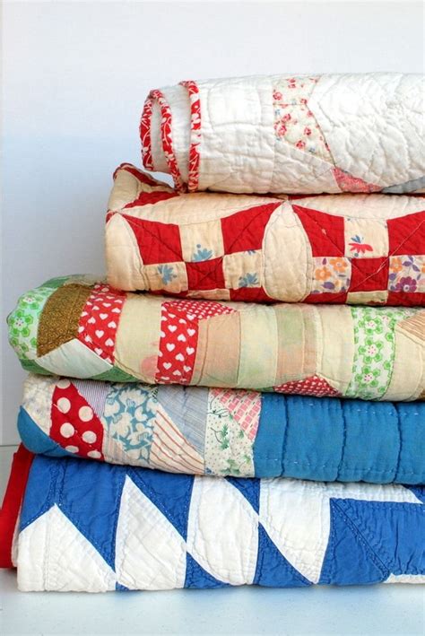 A Stack Of Quilts Sitting On Top Of Each Other