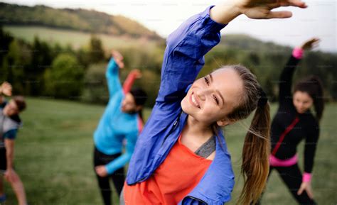 A large group of fit and active people doing exercise in nature