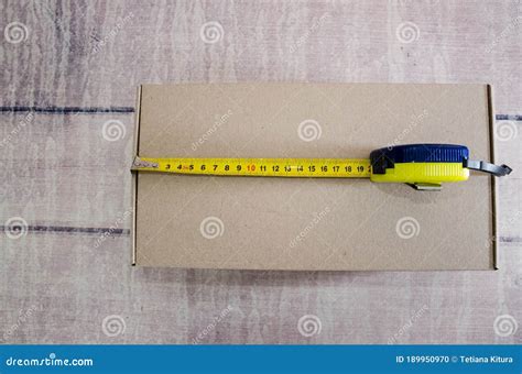 Cardboard Box With Tape Measure On A Wooden Background Box Size