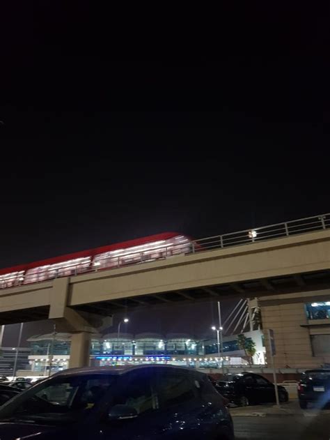 A Red Train Traveling Over A Bridge At Night